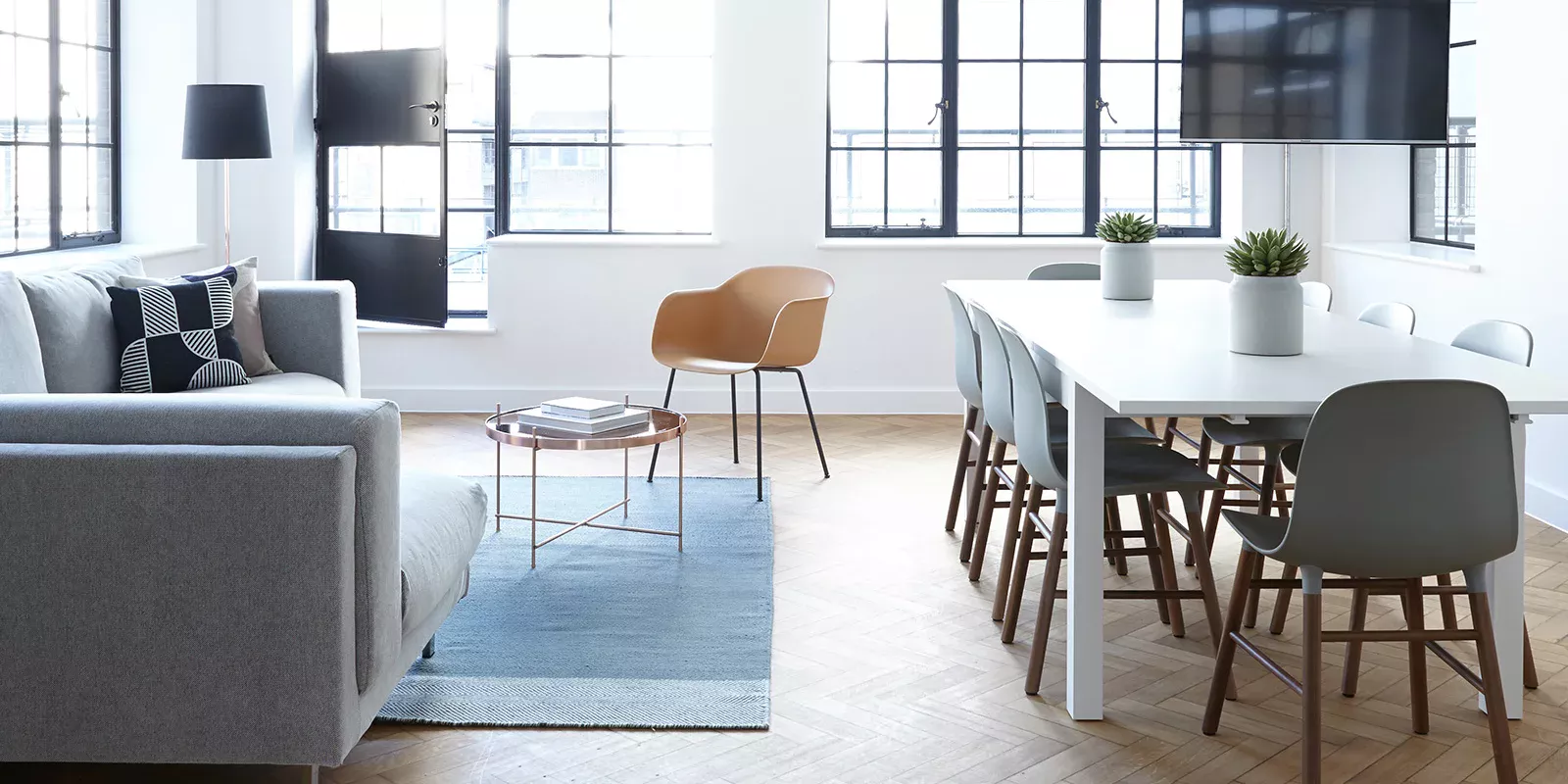 Bright open-plan living and dining space with large industrial windows