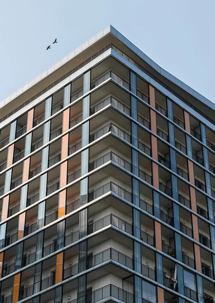 Modern apartment block with balconies and coloured cladding panels